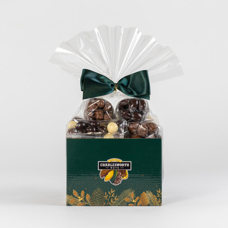 Christmas gift basket adorned with green bow and filled with milk chocolates, dark chocolate and white chocolate.