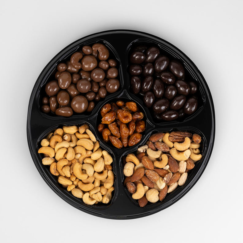 Plate of snacks including dark and milk chocolate and salted nuts