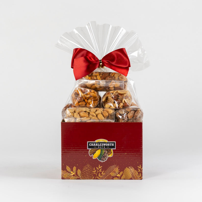 Red Christmas gift basket filled with savoury nuts and adorned with red bow.