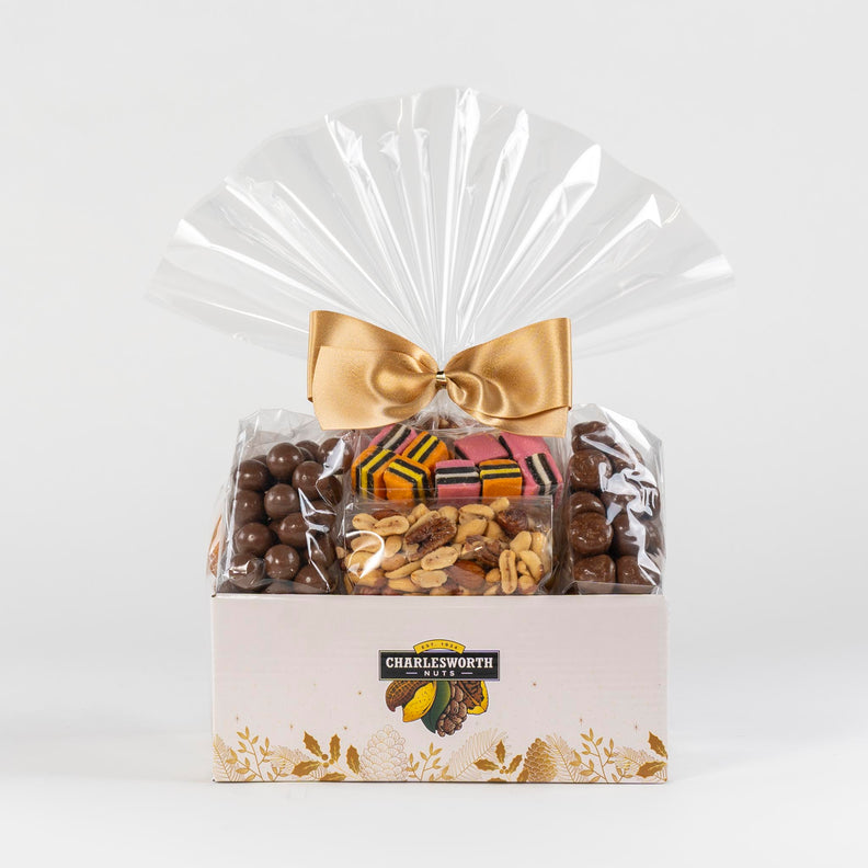 Christmas gift basket beautifully wrapped with a gold bow and filled with nuts and chocolates