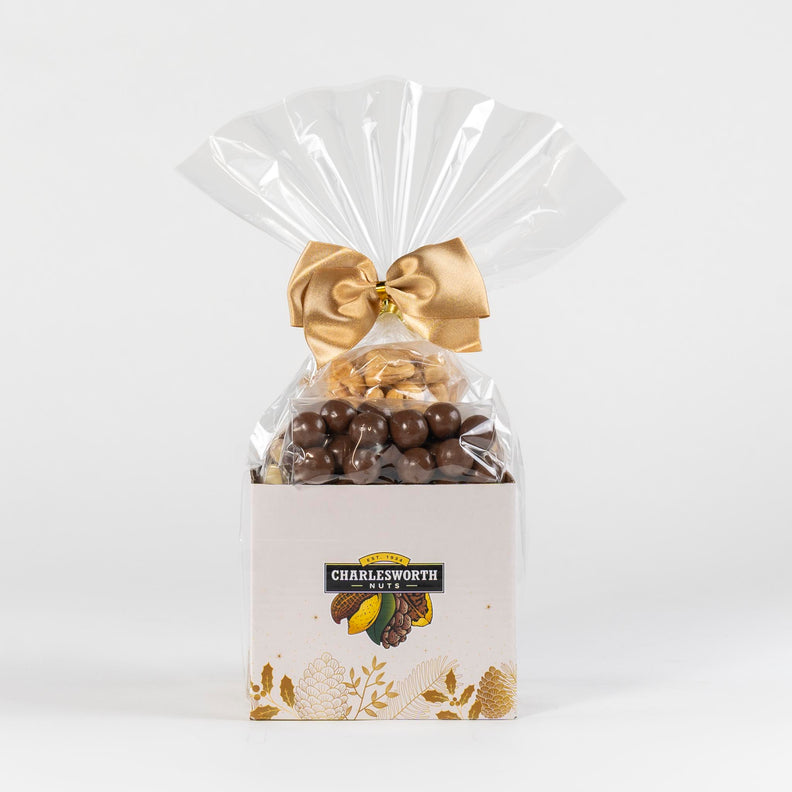 Christmas gift basket filled with sweet chocolates and savoury nuts. Adorned with a gold bow.