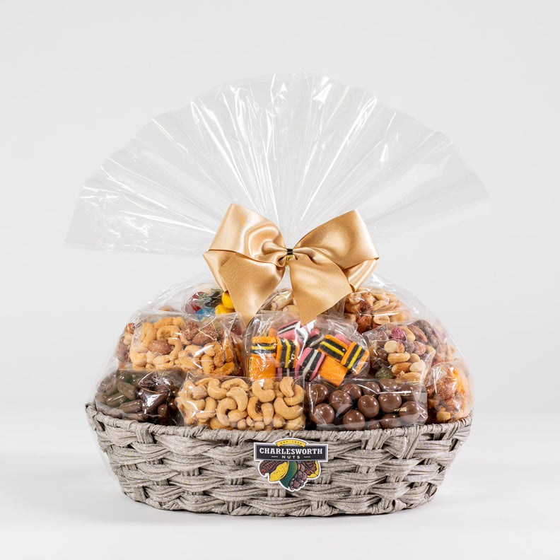 Gift basket containing 16 exquisitely wrapped Charlesworth Nuts and assorted chocolates, carefully arranged in a reusable woven basket.